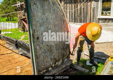 A closeup shot of a construction worker using a hammer on a large piece of wood Stock Photo