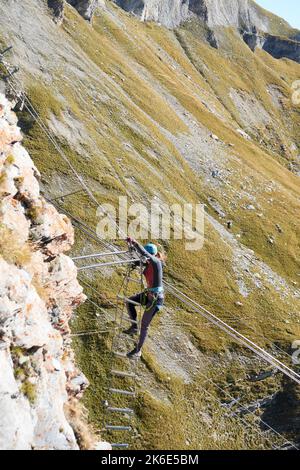 Climber Ascends The 540° Grade Ladder On The Gemmiwand Via Ferrata. Leukerbad, Valais, Switzerland. Stock Photo