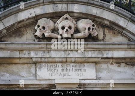 Skulls over the entrance to the churchyard at Saint Olave's Church of England, London England United Kingdom UK Stock Photo