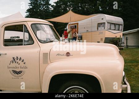 A vintage Ford F-250 pickup and Shasta camping trailer owned by Lavender Fields at Puckin Blossom Farms are parked in the grass at the League of New H Stock Photo