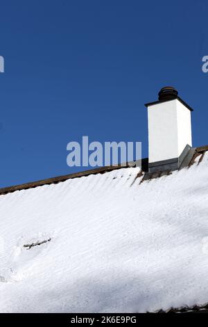 White chimney and roof with snow. A cold winter and possible lack of fuel and firewood Stock Photo