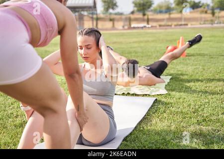 three young sportsmen training on the grass of a public park Stock Photo