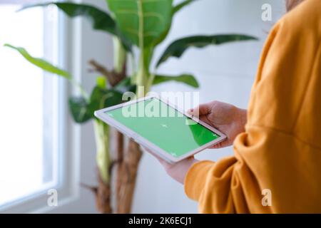 Girl using iPad tablet viewing green screen press browsing chroma key online typing text reading social media close up hands 13.12.21 St.Petersburg Stock Photo