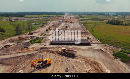Heavy earthmoving machinery on a huge road construction site. Long-reach excavators, bulldozers, dump trucks. Warsaw, Poland. High quality photo Stock Photo