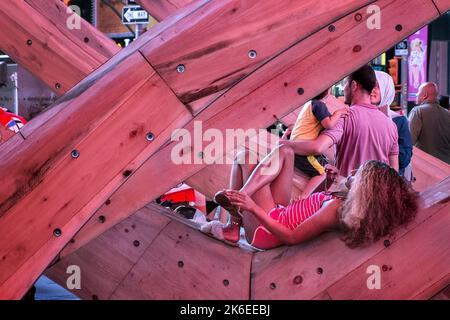 Times Square, New York City, woman stretched out on wooden sculpture Stock Photo