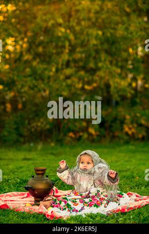 girl in a Russian costume. Little girl in traditional Russian folk costume. Stock Photo