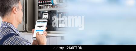 Technician Reading Electric Meter Using Mobile Phone Stock Photo