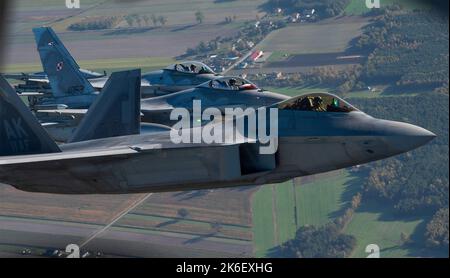 Lask, Poland. 12th Oct, 2022. A U.S. Air Force F-22 Raptor fighter aircraft assigned to the 90th Expeditionary Fighter Squadron conduct a NATO Air Shielding mission with two Polish Air Force F-16 fighters, October 12, 2022 near Lask, Poland. Credit: SSgt Danielle Sukhlall/U.S Air Force/Alamy Live News Stock Photo