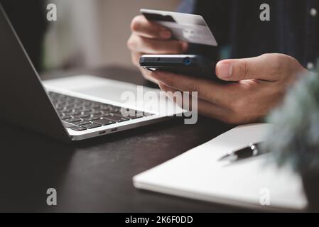 man paying and shopping with smartphone application e commerce wallet app technology. Man using mobile phone and credit card paying via mobile banking Stock Photo