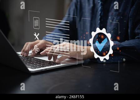 Businessman using laptop computer with quality assurance and document icon for ISO management strategy marketing technology concept. Stock Photo