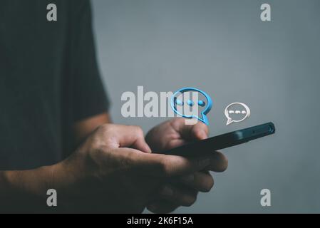 Man hand typing on mobile smart phone digital web chatting on application and social network icon bubble speech 3D. Stock Photo