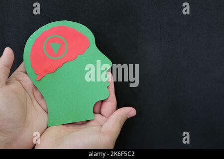 Human head profile with triangle play button symbol on brain. Video watching and digital streaming addiction concept. Stock Photo