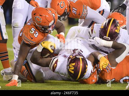 Washington Commanders running back Brian Robinson Jr. runs in for touchdown  over Chicago Bears defensive lineman Armon Watts in the second half of an  NFL football game in Chicago, Thursday, Oct. 13