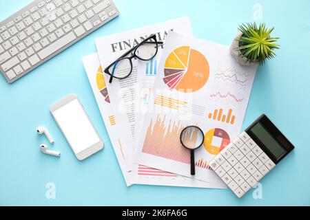 Business charts, gadgets and stationery on blue background Stock Photo