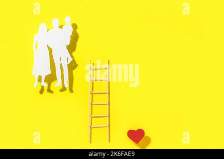 Family silhouette, ladder and heart on yellow background Stock Photo