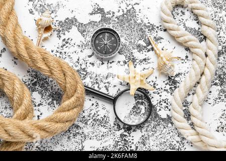 Magnifier, compass, ropes and seashells on grunge background Stock Photo