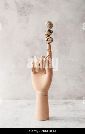 Wooden hand with quail eggs om light grunge background Stock Photo