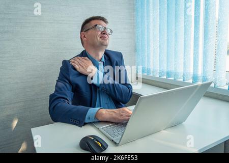 businessman work with computer late at night room. He tired and stressed needs rest. He has shoulder neck and back pain. Working hard and overtime too Stock Photo