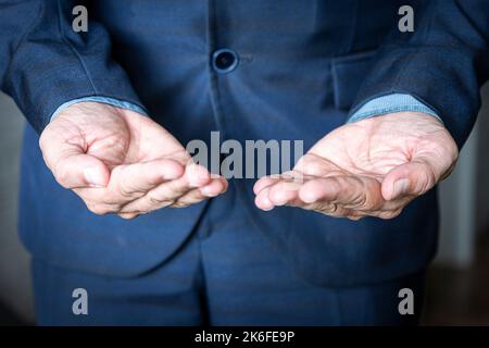 Businessman without head holding something without theme. A beggar man in a jacket is begging. The concept of choice. Stock Photo