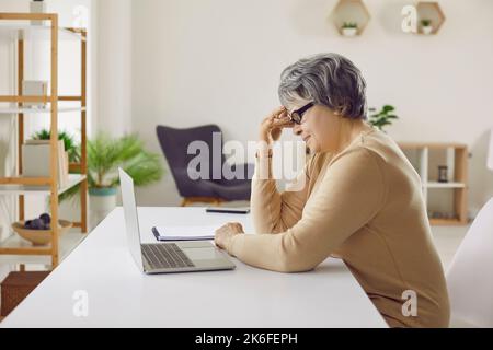 Unhappy mature woman have problems with computer Stock Photo