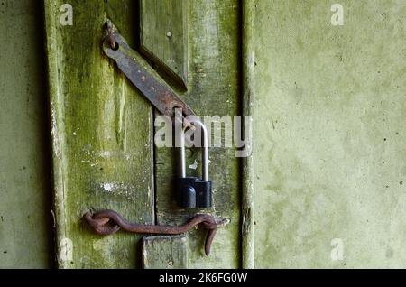 The old door to the building. Wood texture grunge background, scratched green paint on plank of wooden door Stock Photo