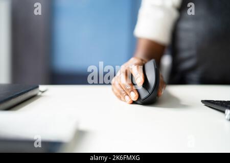 African American Woman With Wrist Pain Using Ergonomic Vertical Mouse Stock Photo