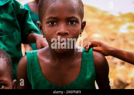 Amedzofe, Ghana - April 07, 2022: African Pupils in Colorful School Uniform near the small Ghana Amedzofe town Stock Photo