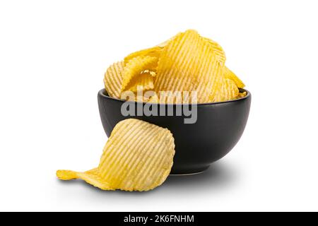 View of dry crispy fried corrugated potato chips in black ceramic bowl isolated on white background with clipping path. Stock Photo