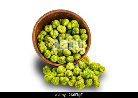 Wasabi coated green peas flowing out of falling wooden bowl isolated on white background with clipping path. Stock Photo