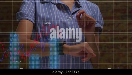 Composite of multiple graphs over midsection of caucasian businesswoman checking smartwatch Stock Photo