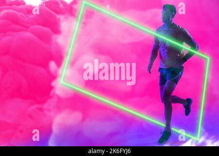 Full length of caucasian sportsman running over illuminated rectangle against pink smoky background Stock Photo