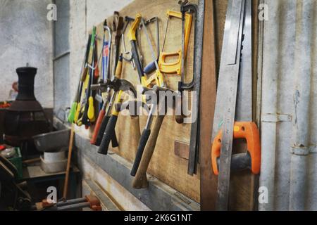 Tools hanging on rack in workshop Stock Photo