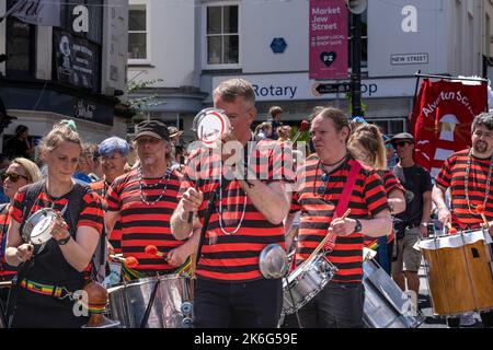DakaDoum the Afro/Brazilian Percussion Band performing in Penzance town centre on the colourful Mazey Day procession in Cornwall in England in the UK. Stock Photo