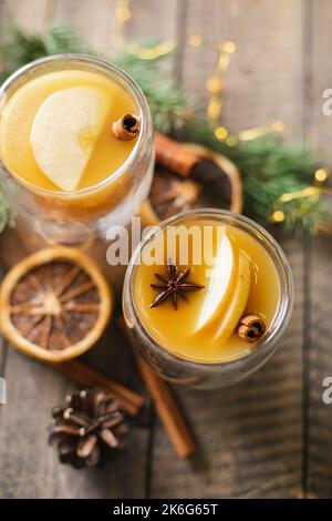 Hot apple cider with cinnamon sticks, apple and holiday christmas decoration. Top view. Stock Photo