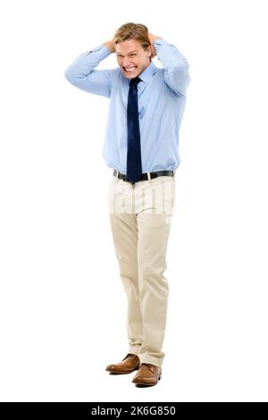 Im in trouble. Full length shot of a handsome young businessman standing in the studio with his hands behind his head in excitement. Stock Photo