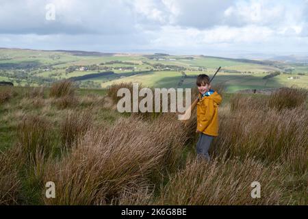 Earl Crag, North Yorkshire, UK.  Six year old boy with toy broom ot walking in the Yorkshire countryside. Stock Photo