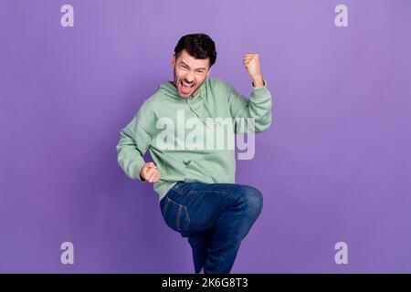 Photo of young funny positive impressed crazy stylish outfit guy showing fists up celebrate his victory tournament isolated on violet color background Stock Photo