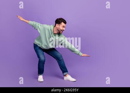 Side profile photo of youngster man taking balance interested excited looking empty space information about opening gym isolated on violet color Stock Photo