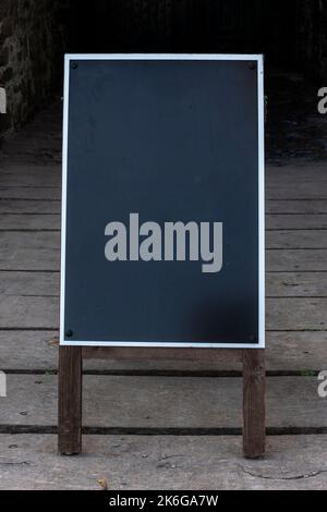 Blank notice board sign on a chalkboard blackboard wooden frame placard with a white border on a black background, stock photo image Stock Photo