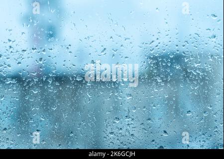 Bad weather day, rain on glass window. Close up view of water drops falling on glass. Rain running down on window. Rainy season, autumn. Raindrops tri Stock Photo