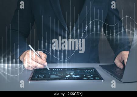 Businessman using tablet and laptop. digital diagram,graph interfaces,virtual screen,connections icon on blurred background. digital transformation an Stock Photo