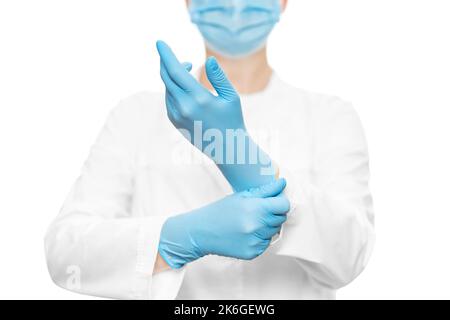 Doctor in a protective suit puts on a blue medical glove Stock Photo