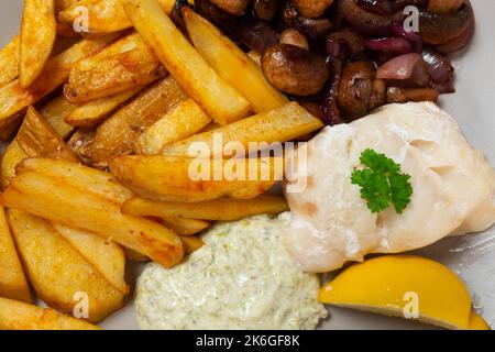 Close up of baked cod loin, skin on chips, sauteed mushroom and red onion, tartare sauce Stock Photo