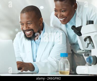 Take a look at these results. two scientists using a laptop in a laboratory. Stock Photo