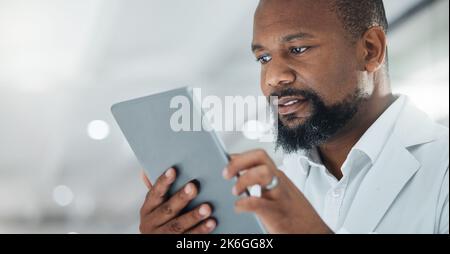 Science is all about extensive work. a male scientist using a digital tablet while working in a lab. Stock Photo