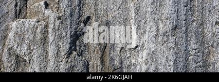 Natural rock background. Gray grunge banner. Abstract stone background. The texture of the stone wall close up. Light gray rock backdrop. Long Banner Stock Photo