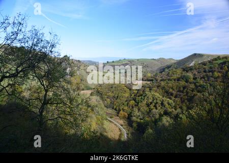 The wooded hillsides and limestone pinnacles  along the Manifold valley trail, echo back some 300 million years when this landscape formed . Stock Photo