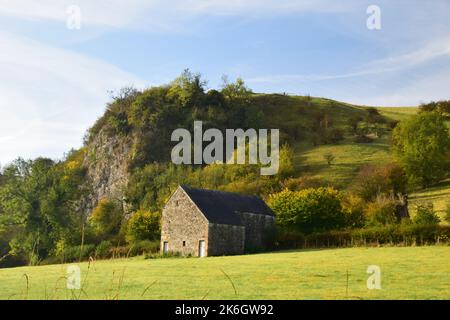 The wooded hillsides and limestone pinnacles  along the Manifold valley trail, echo back some 300 million years when this landscape formed . Stock Photo