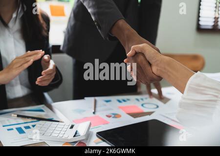 Group business people handshake at meeting table in office together with confident shot from top view . Young businessman and businesswoman workers Stock Photo