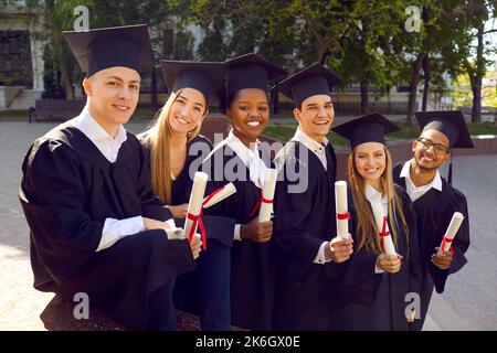 Happy graduates celebrate their graduation and rejoice at successful completion of their studies. Stock Photo